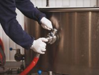 unrecognizable-maintenance-worker-checking-beer-tank-microbrewery_118628-2655
